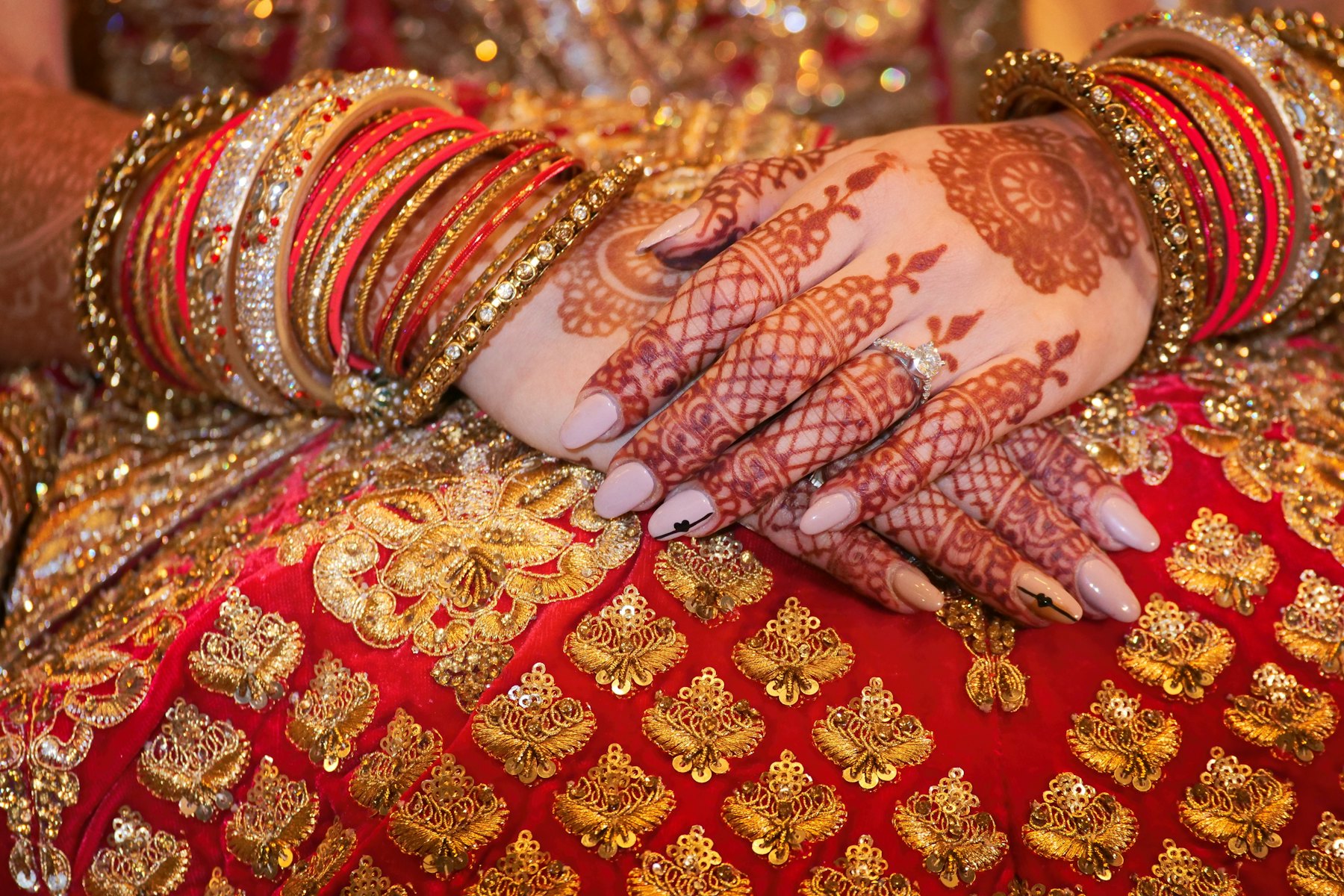 Mehndi-covered hands resting on gold brocade